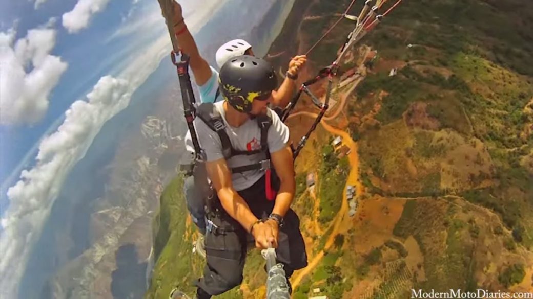 A man is paragliding over a mountain, capturing the stunning views of the world below.
