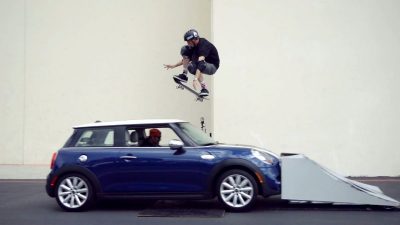 A skateboarder attempting Ollies on a moving car, inspired by Tony Hawk's iconic tricks.