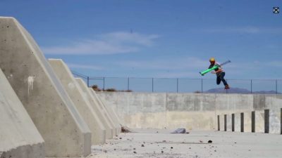 A skateboarder performing a trick on a concrete wall.