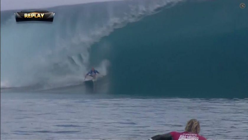 Kelly Slater grabbing rail on his 10 point opening ride as John John Florence enjoys the view. Screen grab from ASP footage.