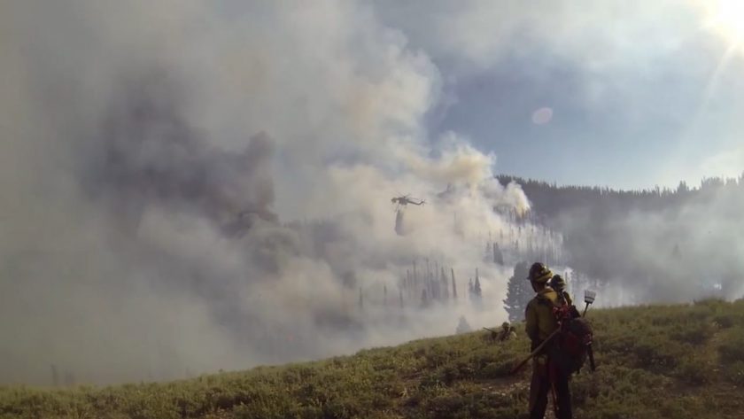 Pretty cool view of a chopper dumping fire retardant into the flames. Photo is a video screen shot.