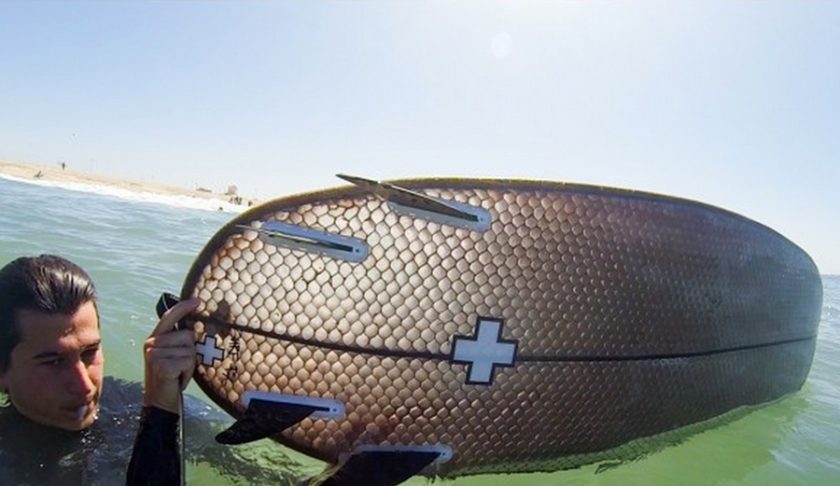 The paper surfboard works well in the water and is super light to carry, maybe not so good on windy days though. Screen grab from video.