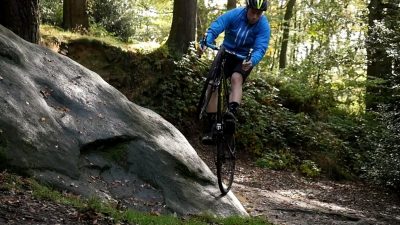 A man riding a mountain bike through the woods.