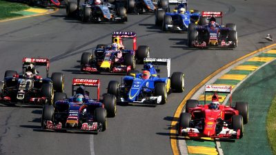A group of racing cars speeding down the track at the Australian GP.