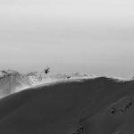 A black and white photo of a skier on a snow-covered mountain from the Valdez Heli Ski Guides.