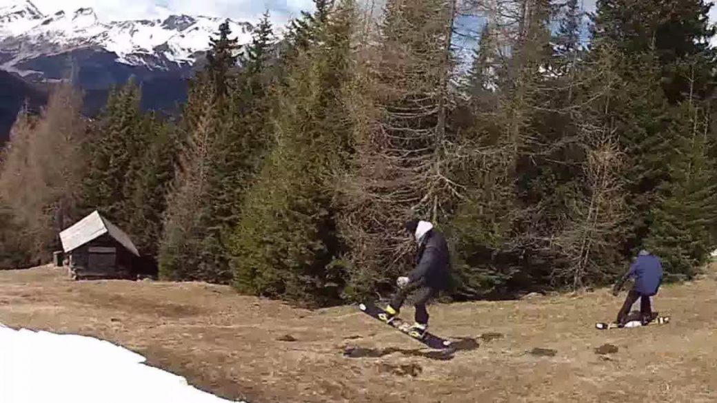 A group of people are snowboarding in the mountains.