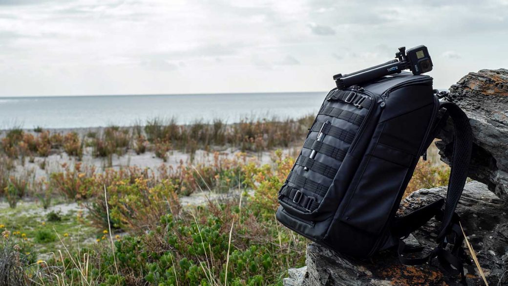 Black backpack on rock next to body of water