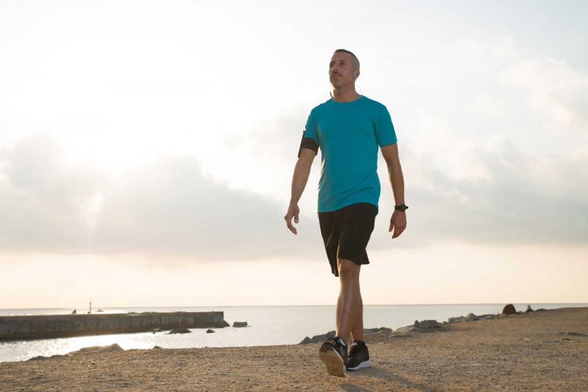 Man walking on the coast while listening to music