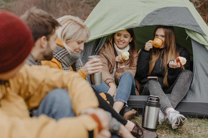 Group of friends camping and sharing a meal