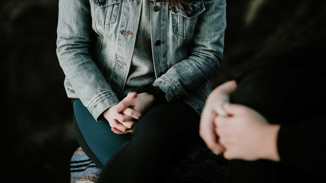Woman wearing grey denim jacket in a counselling session