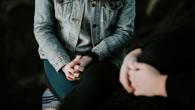 Woman wearing grey denim jacket in a counselling session