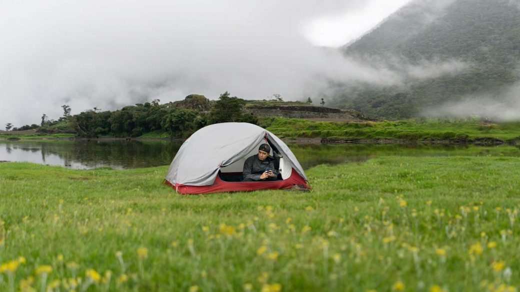 Man camping below a fog covered mountain