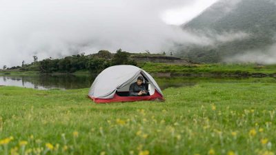 Man camping below a fog covered mountain
