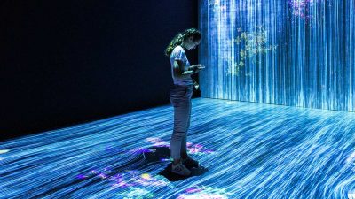Woman looking at phone in science exhibit
