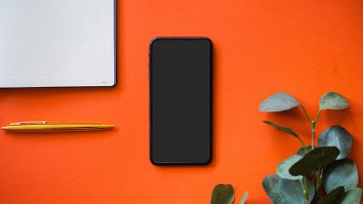 Black mobile phone on orange surface