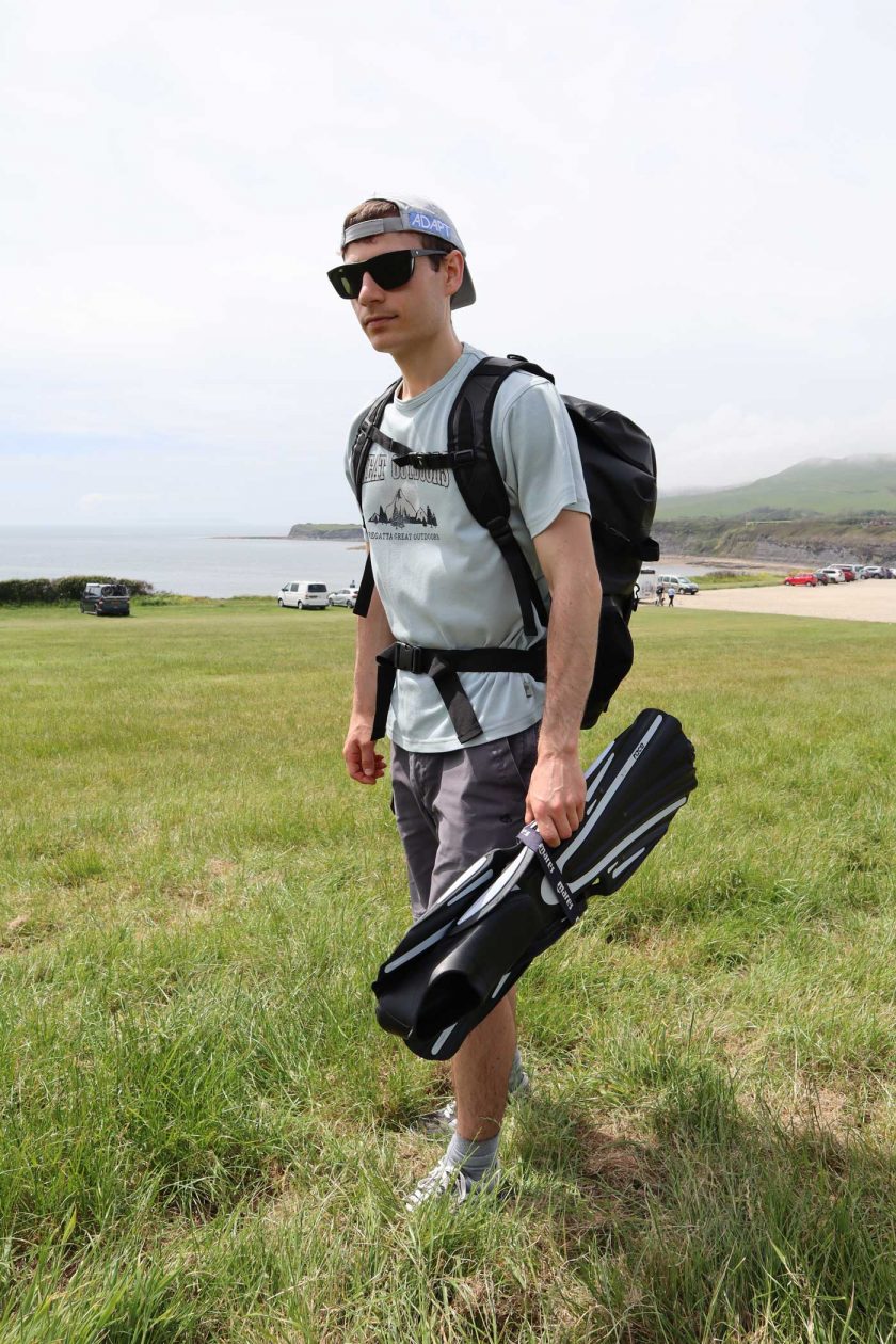 Carrying the DryTide 50L waterproof backpack whilst holding a pair of flippers