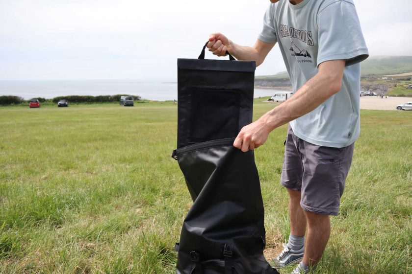 Removing the laptop sleeve from the DryTide 50L waterproof backback for easy access