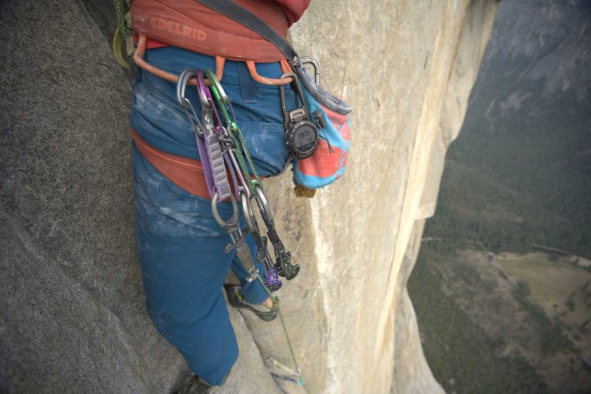 Rock climber with the COROS VERTIX 2 GPS adventure watch attached to harness using carabiner accessory