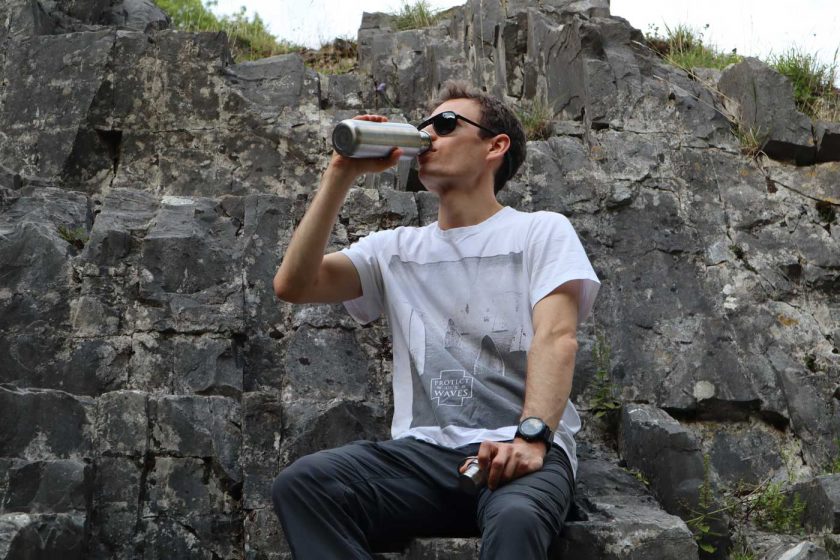 Drinking water from a stainless steel water bottle and looking at a rock climbing route in Cheddar through the Vallon Howlin’ sunglasses