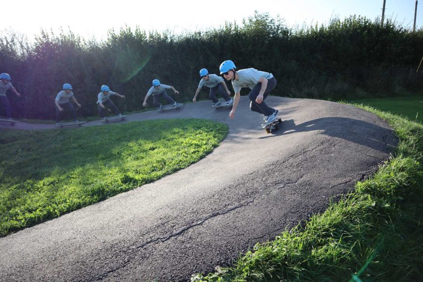 Performing a backside carve on a SwellTech Hybrid surfskate skateboard on a pump track