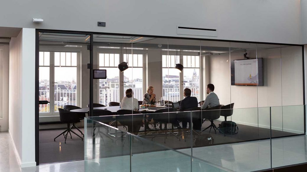 Colleague sat around an office table having a business meeting with the company director