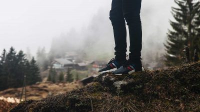 Person standing on rock wearing 90s sneakers