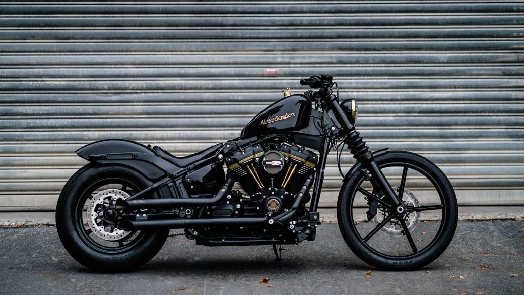 Black Harley-Davidson motorcycle parked against a grey wall