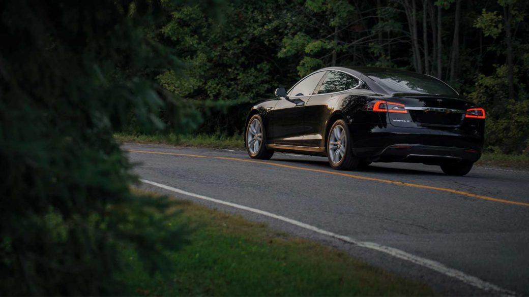 Tesla Model S driving on a forest road