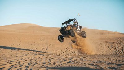 Man driving a UTV dune buggy in the desert