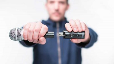 Man attaching a wireless microphone adaper to a dynamic microphone