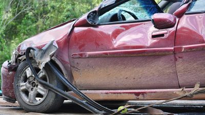 Damaged red car on a tow truck after a car accident