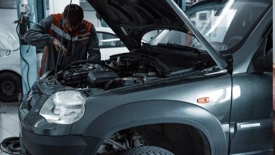 Car mechanic fixing a grey SUV