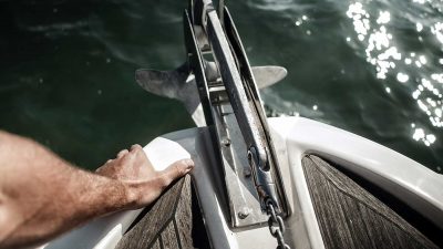 Person dropping the anchor of a small boat