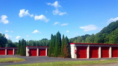 Outdoor storage units with red garage doors