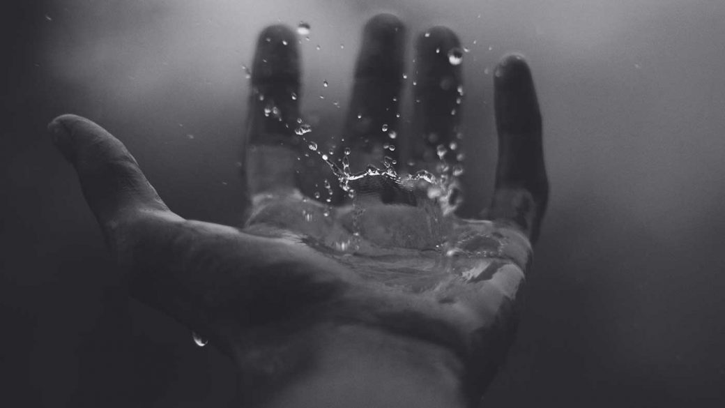 Black and white image of a hand cupping water