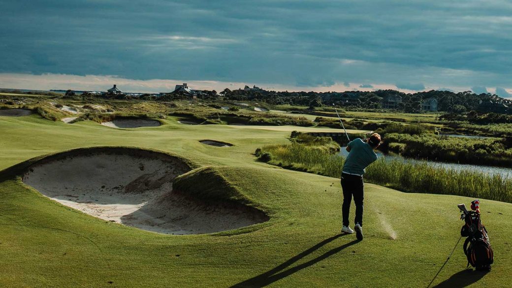 An experienced golfer playing golf under a cloudy sky
