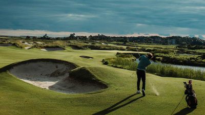 An experienced golfer playing golf under a cloudy sky