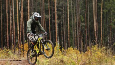 Mountain biker performing a manual on a yellow full-suspension mountain bike