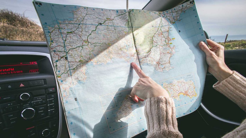 Person searching a map for a place to eat on a road trip