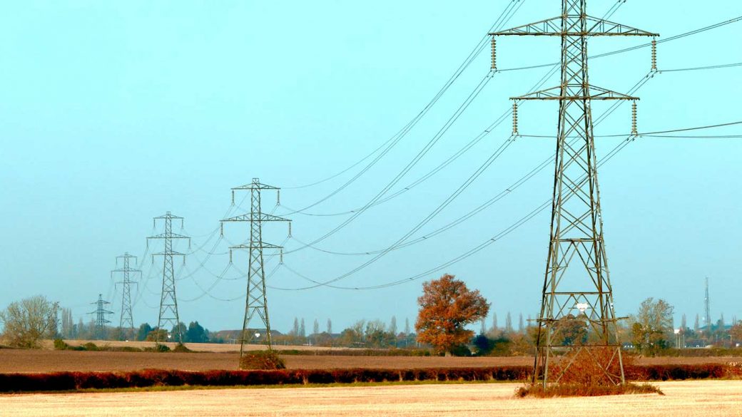 Electricity pylons running across UK countryside