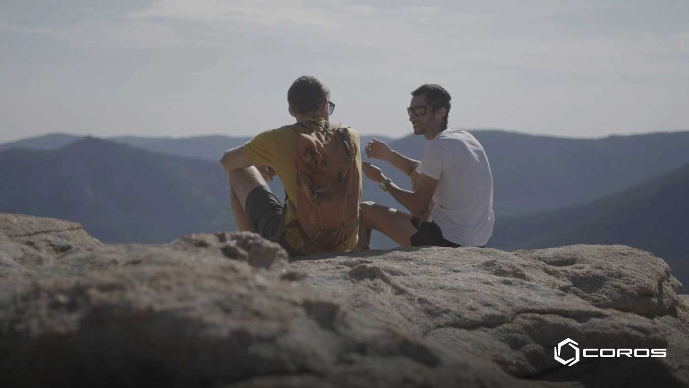 Tommy Caldwell and Kilian Jornet sitting together on a cliff for their ‘Coros Convo’