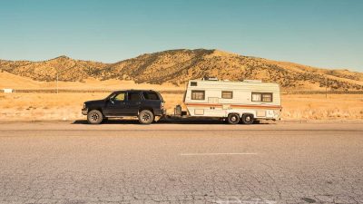 Black SUV towing a trailer on a desert road