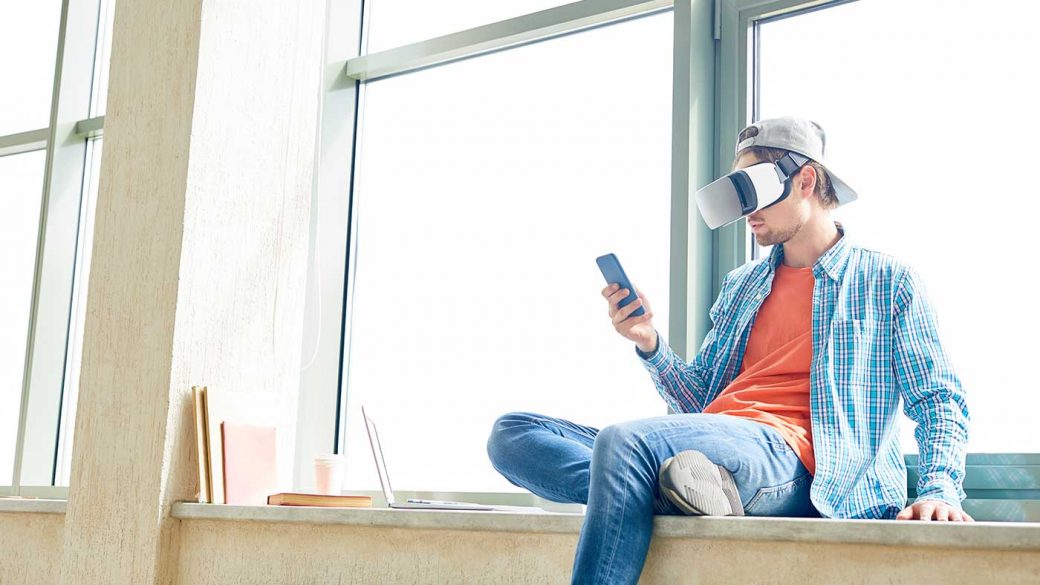 Man playing online bingo using a Smartphone and VR headset