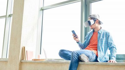 Man playing online bingo using a Smartphone and VR headset