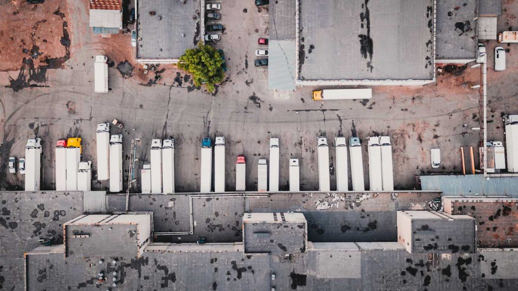 Bird's-eye view of a fleet of trucks parked at a truck depot
