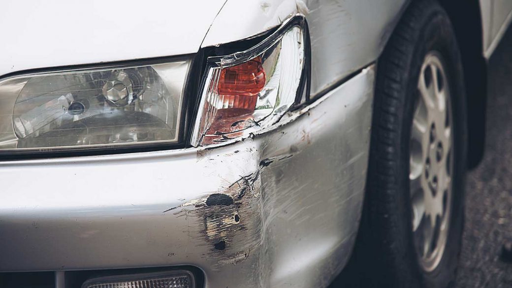 Dent in the front bumper of a silver car