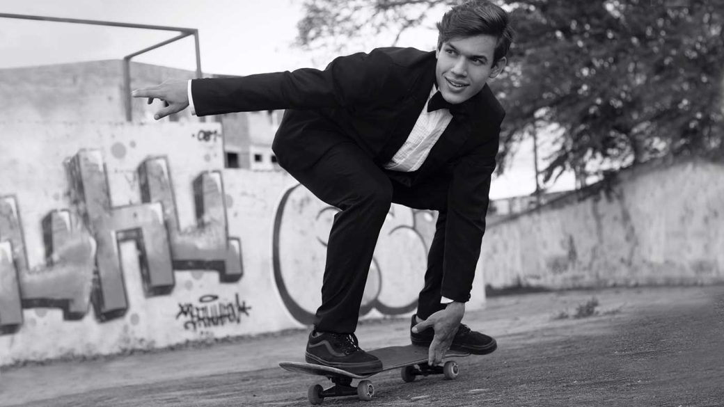 Man riding on a skateboard while wearing a tuxedo suit