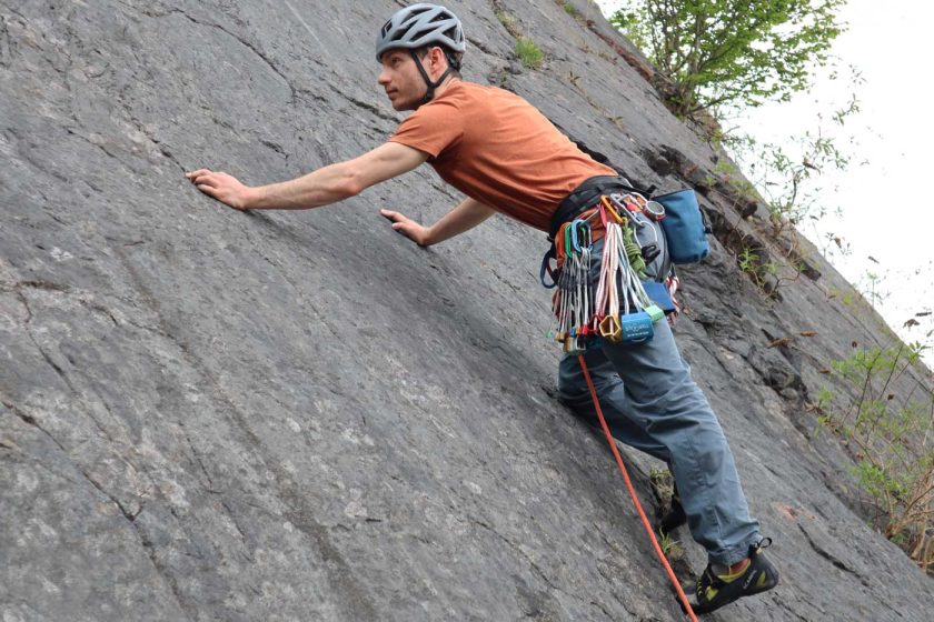 Eyeing up a potential gear placement on a slab trad climb