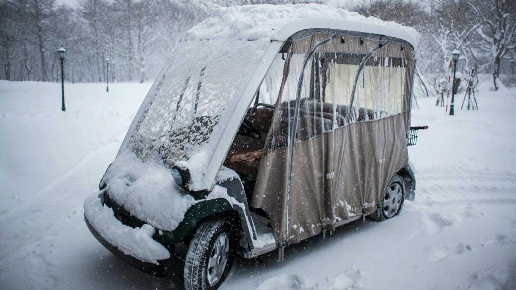 Golf cart covered in snow